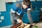 A working cabinetmaker holds a brush in his hand and paints a wooden surface. A trace of paint on a wooden board.