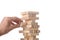 Working  concept:  man`s hand positioning a wood block in a tower made with wooden blocks with clipping path and copy space for y