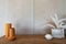 Working corner decorated with mustard color ceramic vase with artificial plant inside vase on wooden top set in natural light