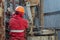 A working driller is screwing drill pipes to run into the well.