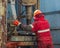 A working driller is screwing drill pipes to run into the well.