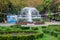 The working fountain. Palm trees. Green decorative flower bed