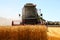 Working harvesting combine in the field of wheat