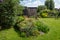 Working from home in London. Rockery in the foreground. Garden studio office room with black and cedar cladding behind.