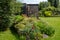 Working from home in London. Rockery in the foreground. Garden studio office room with black and cedar cladding behind.