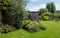 Working from home in London. Rockery in the foreground. Garden studio office room with black and cedar cladding behind.