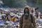 A working man in a gas mask against the backdrop of burning garbage. A lot of plastic bags thrown to the dump. From the plastic de
