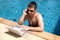 Working man with laptop in pool