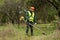 A working man in professional outfit mows grass with a trimmer, a mower. Mowing lawns, roadsides, edge