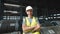 A working man in a rolled metal warehouse. A man in overalls and a protective helmet.