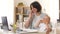 Working mother with baby calling on smartphone