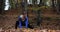 Working out in the park. Young woman in blue jacket gets ready for running stretching her arms and legs in beautiful