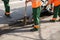 Working paver sweeps debris out of the hole before the repair of the road.