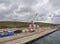 The working Peterson Quay in the town of Lerwick, with a fenced off working area with a mobile Crane. .