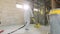 Working process at a construction site. Workers in protective suits are grinding the concrete floor. Construction