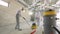 Working process at a construction site. Workers in protective suits are grinding the concrete floor. Construction