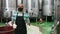 Working process at winery, man worker in protective mask working with fermentation tank