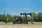 Working pump jack pumping crude oil at oil drilling site in rural USA