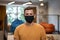 Working safely during coronavirus. Portrait of young man, male office worker wearing black protective mask and looking