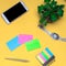 Working space with a clock, telephone, stickers, notes on a yellow background. place for text. The working space of a freelancer,