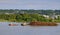 A working tugboat towing a cargo ship full of logs on a river