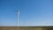 Working twisting windmills stand in a field in summer