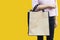 Working woman carry simple flax eco shopping bag  on yellow background