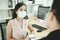 Working woman wearing protection face having friendly conversation and drinking coffee