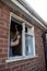 Workman holding up a crowbar to remove old wooden window