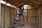 Workman installing interior of shed