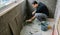 Workman laying tiles on a terrace