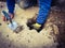 A workman reaching into a hole he`s been digging to pull out earth and rubble