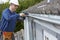 Workman Replacing Guttering On Exterior Of House