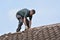 Workman replacing roof tiles and ridge tiles
