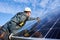 Workman standing on the ground trying to fasten solar batteries together, installing process