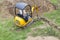 Workman using a mini digger to dig a hole for a swimming pool