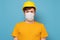 Workman wearing a yellow hard hat and medical mask during quarantine