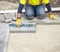 Workman in Yellow Safety Jacket Laying Patio Paver Stones 1