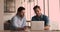 Workmates sit at workplace desk using laptop discuss online presentation
