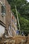 Workmen on ladders replace windows on a brick building undergoing renovation