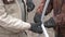 Workmen in raggett gloves tightening bolts on construction frame