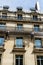 Workmen on ropes on old residential building front, Paris.