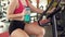 Workout in gym, slim woman drinking water while riding exercise bike, fitness