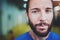 Workout indoor lifestyle concept.Portrait of young bearded man athlete standing in fitness gym on blurred background