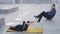 Workout with personal trainer outdoors. Woman lies on yellow mat doing air cycling. The coach demonstrating the proper