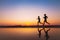 Workout, silhouettes of two runners on the beach