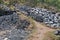 Workplace of Balinese stone gatherers. Sorted boulders by size. Natural building material. Hard work. Stones thrown from the sea a