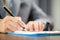 Workplace closeup person professional businesswoman sitting at desk hold pen signing or signature contract paper. Employee woman