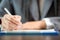 Workplace closeup person professional businesswoman sitting at desk hold pen signing or signature contract paper. Employee woman