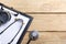 Workplace of a doctor. Medical clipboard and stethoscope on wooden desk background. Top view